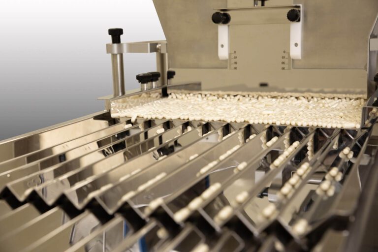 tablets in the vibrating chute of a counting machine